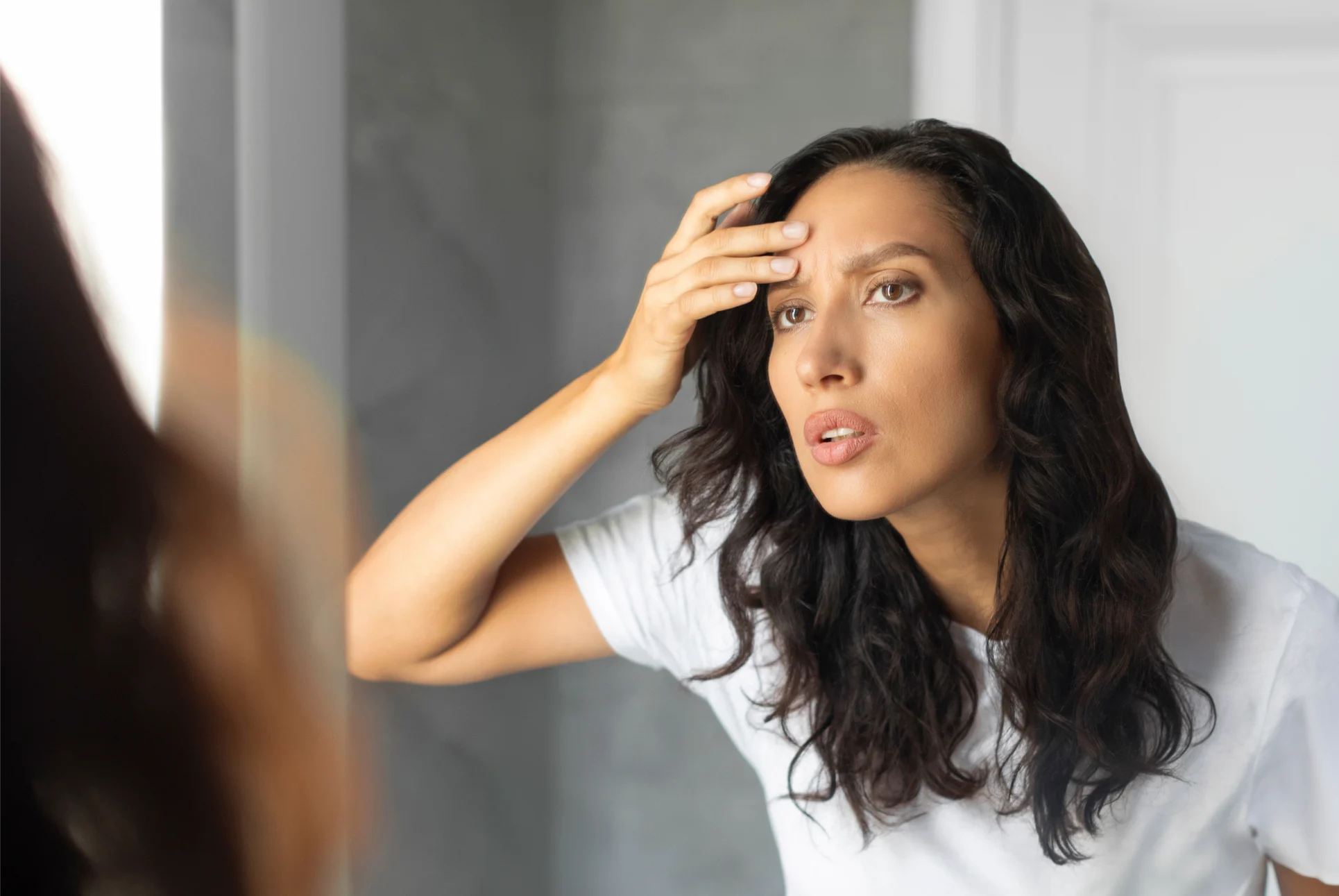 Woman showing areas treated by neuromodulators including forehead and crow's feet at Gold Skin Care Nashville